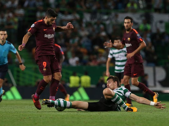 Barcelona's Luis Suarez, left, is challenged by Sporting's Bruno Cesar, during a Champions League, Group D soccer match between Sporting CP and FC Barcelona at the Alvalade stadium in Lisbon, Wednesday Sept. 27, 2017. (AP Photo/Armando Franca)