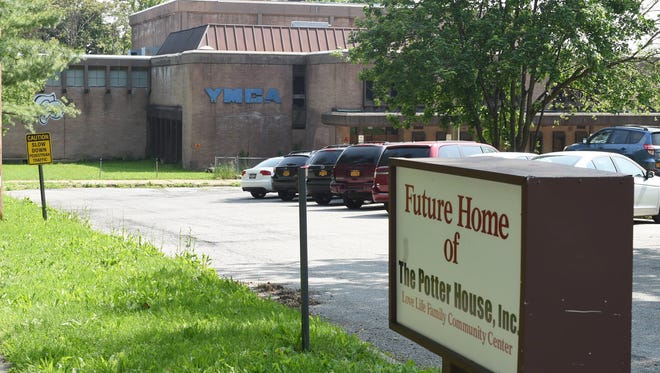 A sign indicating the plan to utilize the former YMCA on Montgomery Street in the City of Poughkeepsie as a community center run by the building's current owner, The Potter House, on Wednesday, May 25, 2016. The plan is currently on hold due to a Tax Lien placed on the property from the City of Poughkeepsie. 