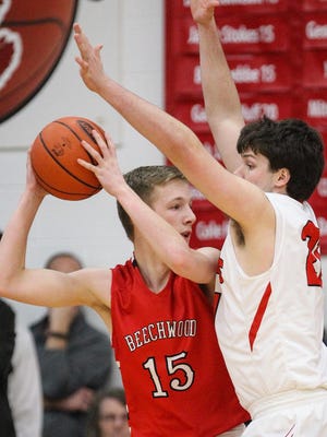Holy Cross' Tyler Bezold gets up and plays defense against Beechwood's Ben Toebbe. The Indians defeated the Tigers in the 35th District semifinals, 50-34.