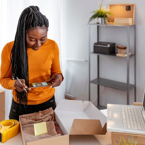 A female small business owner packaging an order t