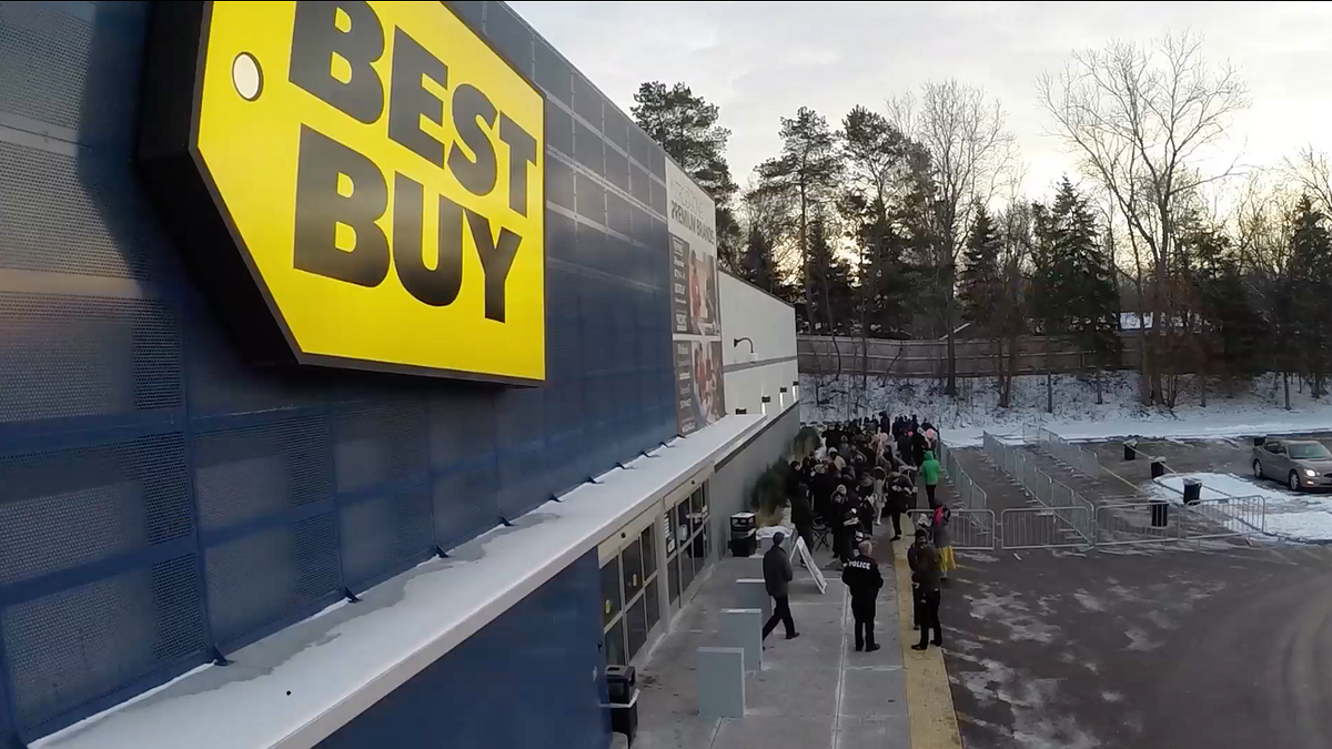 Best Buy storefront with lots of people outside.