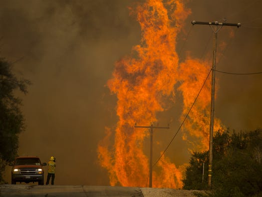 Flames rise as a fire front approaches the Lake Casitas