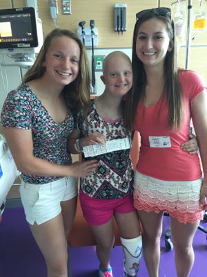 Victoria Marsh, a Middletown girl with cancer and Down syndrome, and her sisters Josephine, left, and Kirsten, right, met Taylor Swift on Saturday.