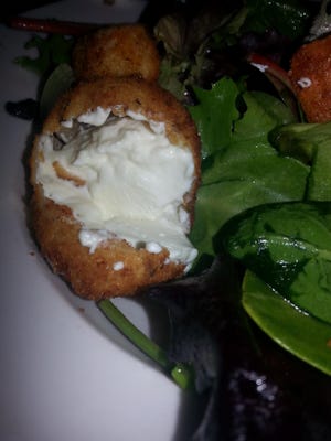 Salad topped with a fried goat cheese ball at Pomodoro East.