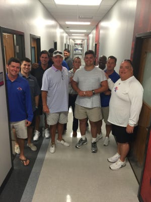 Joshua Mote, center, celebrates his commitment Thursday with Louisiana Tech's coaching staff.