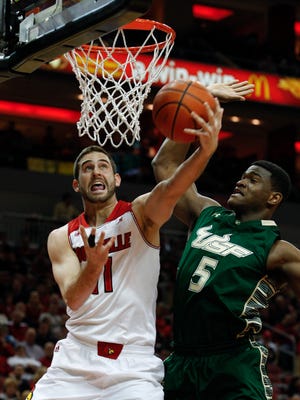 
U of L's Luke Hancock makes a layup around a USF defender at the Yum! Center in February.
