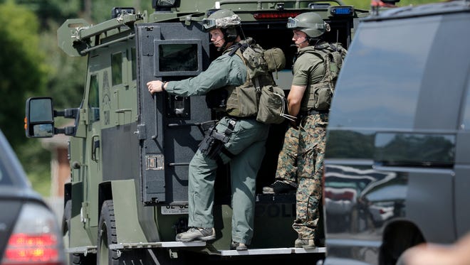 Law enforcement perch on the rear of an armored vehicle as they prepare at a staging area on Hixson Pike to investigate a nearby home on Thursday, July 16, 2015, in Chattanooga, Tenn. At least two military facilities in Tennessee were attacked in shootings Thursday. (Doug Strickland/Chattanooga Times Free Press via AP) THE DAILY CITIZEN OUT; NOOGA.COM OUT; CLEVELAND DAILY BANNER OUT; LOCAL INTERNET OUT; MANDATORY CREDIT