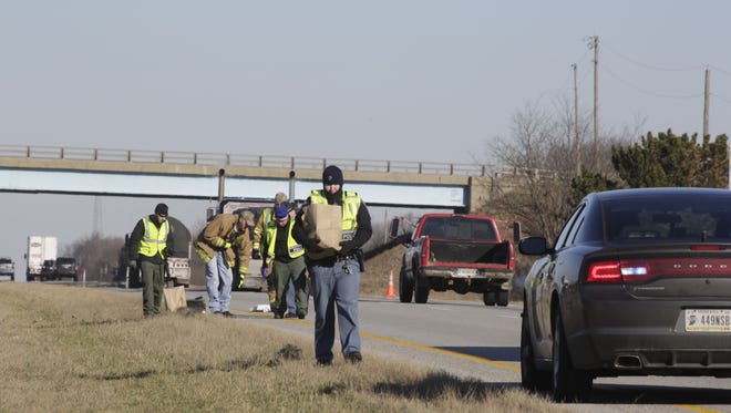 Indiana State Police investigators gather evidence on I-65 after a man was found dead Friday morning near the 165 mile marker.