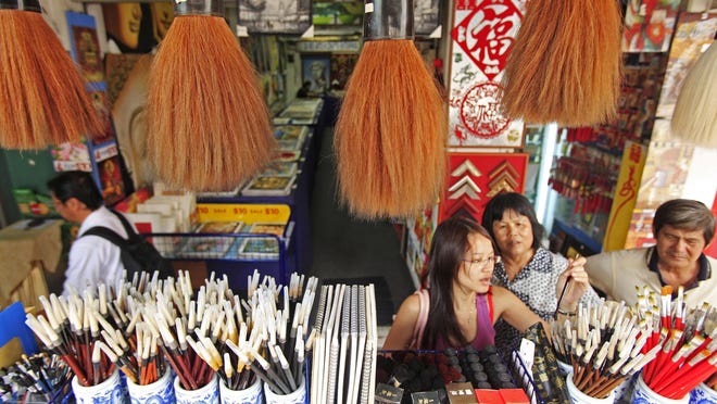 Traditional Chinese calligraphy brushes hang in a shop in Singapore’s Chinatown in this view from 2010.