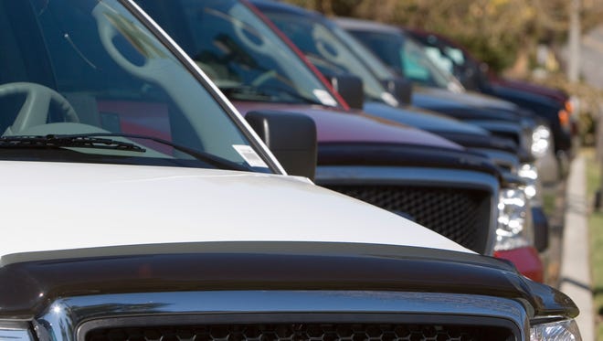 A row of new trucks at a dealership.
