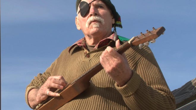 Douglas Berry plays his backpacking guitar on the Asbury Park boardwalk. With a Tom Waits kind of shtick, Berry is a poet who is a staple of the spoken word circuit at the Shore.