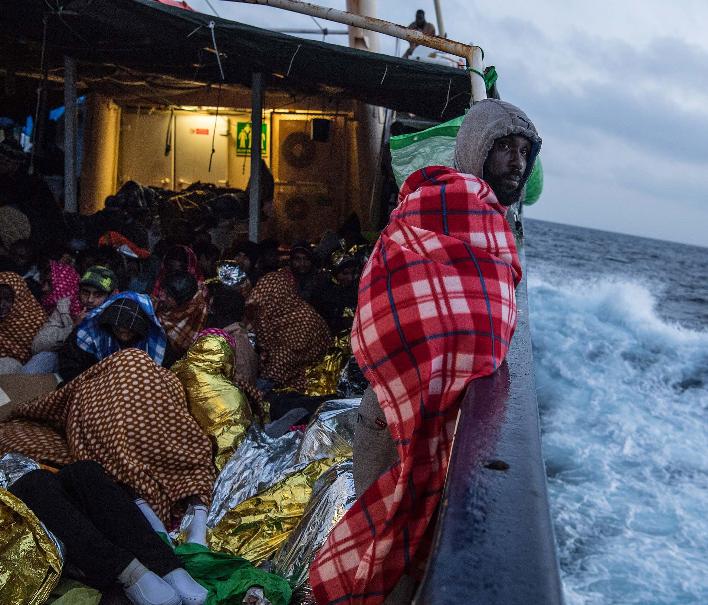 Refugees and migrants are seen on deck of the Spanish NGO Proactiva Open Arms rescue vessel Golfo Azzurro sailing towards the Italian port of Pozzallo after being rescued off Libyan coast north of Sabratha, Libya on Feb. 19, 2017.