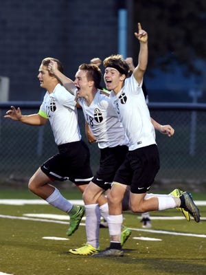 Rosecrans freshman Weston Nern (middle) celebrates with teammates Tucker Zemba (left) and Andrew Nash after scoring the game-winning goal in the second overtime of the Bishops' 2-1 win against Berlin Hiland in a Division III district final on Saturday at Stewart Field.