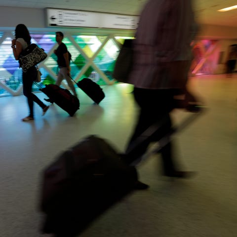 Passengers travel through Miami's airport on Sept.