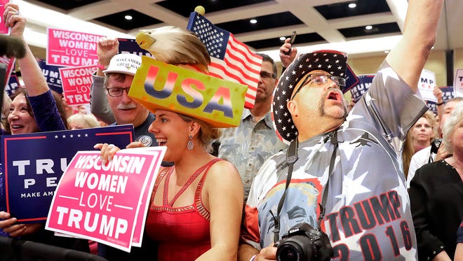 Randall Thom of Wakefield, Minn., right, and Erica Smith of Green Bay cheer as they listen to Presidential candidate Donald Trump at a campaign rally at the KI Convention Center in Green Bay.