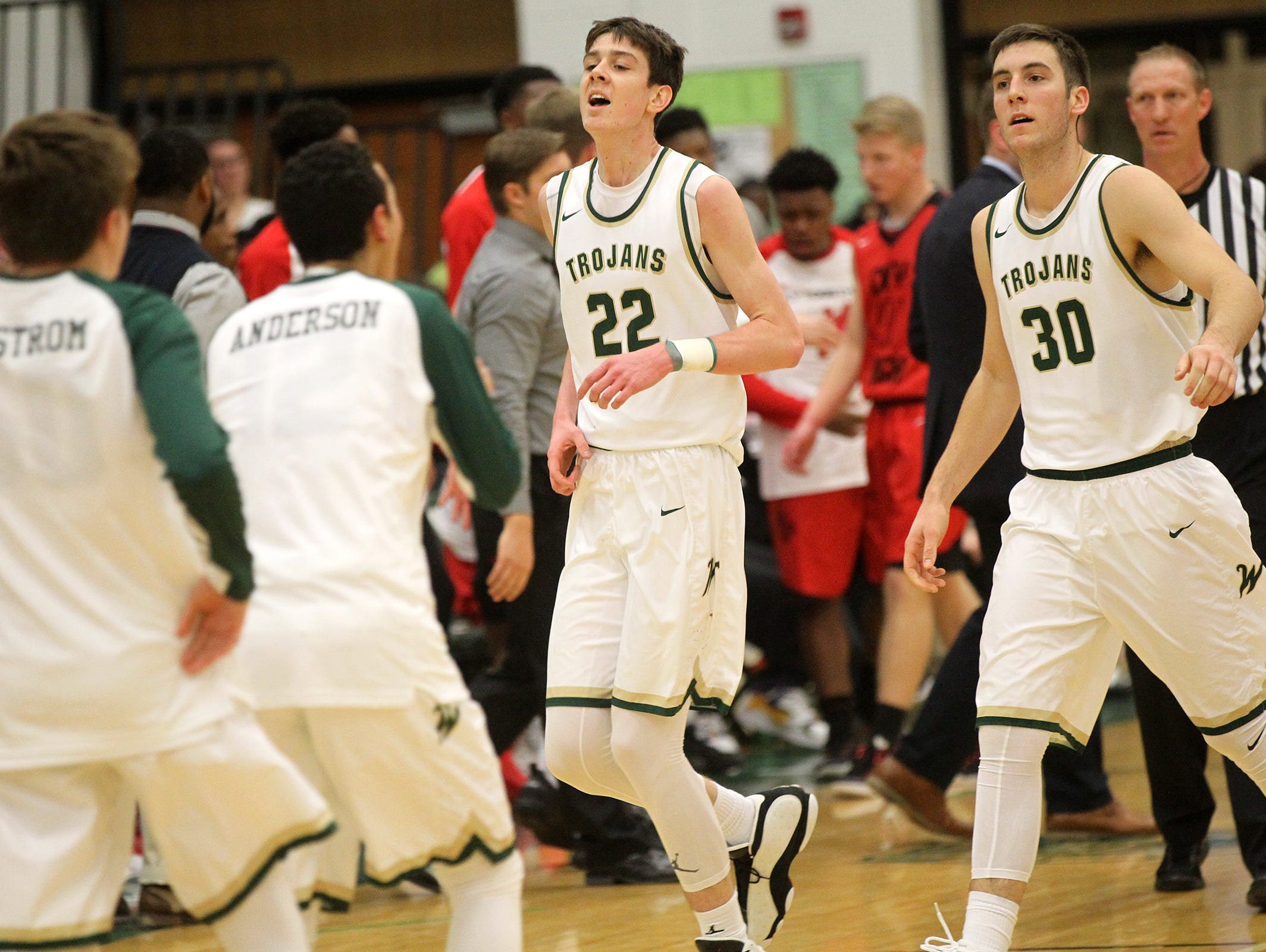 West High's Patrick McCaffery (22) and Connor McCaffery head into a timeout during their game against City High at West High on Tuesday, Dec. 13, 2016.