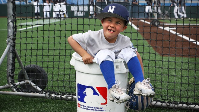 Nevada baseball coach T.J. Bruce's son Jaxon sits in a bucket of ball while hanging with the players during pregame warmups at Peccole Park in Reno on May 5, 2018.
