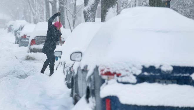 Clementina Posteraro clears a driveway on Averill Street during a snowstorm on Tuesday.
