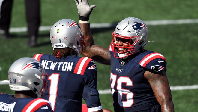 New England Patriots quarterback Cam Newton (1) celebrates with offensive tackle Isaiah Wynn (76) after scoring a touchdown against the Miami Dolphins during the third quarter at Gillette Stadium on Sept. 13, 2020.