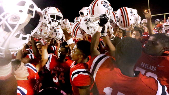 Oakland players celebrate a 17-14 victory over Maryville, snapping the Rebels' 70-game regular-season win streak.