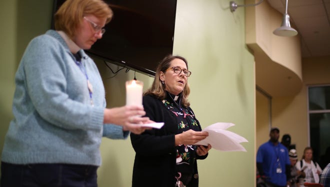 Grace Mission Pastors Amanda Nickles, right, and Jenni Liem read through a list of dozens of names of people who had passed through the doors of the Kearney Center, and died over the last year, during a National Homeless Persons’ Memorial Day ceremony last year.