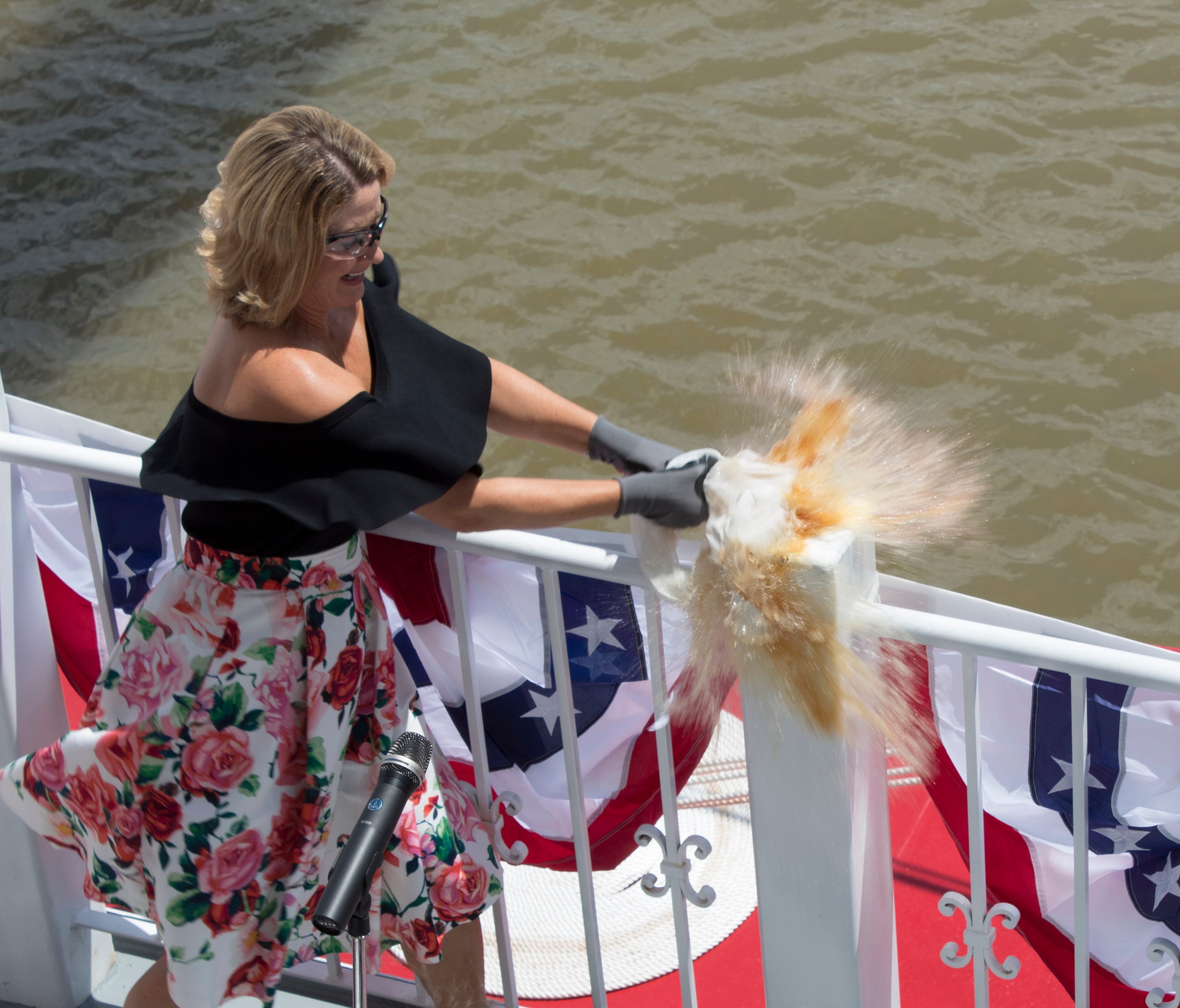 Marissa Applegate smashes a bottle of Maker's Mark bourbon against a railing of the American Duchess riverboat to christen it on Aug. 14, 2017.