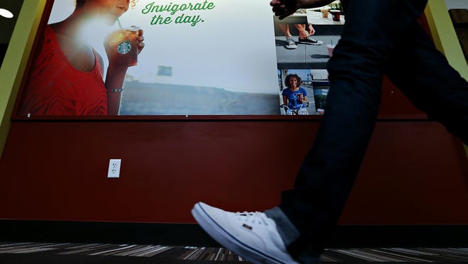 A Marlin employee walks past an advertisement the agency created for Starbucks hanging at Marlin’s offices in Springfield on Sept. 16, 2015.