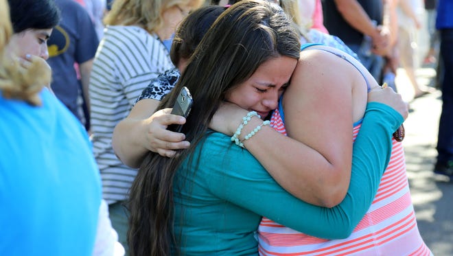 A woman is comforted as friends and family wait for students at the local fairgrounds after a shooting at Umpqua Community College in Roseburg, Ore., on Thursday, Oct. 1, 2015.