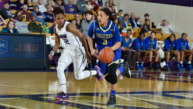 Delaware's Erika Brown dribbles down court while JMU's Angela Mickens defends Friday night.