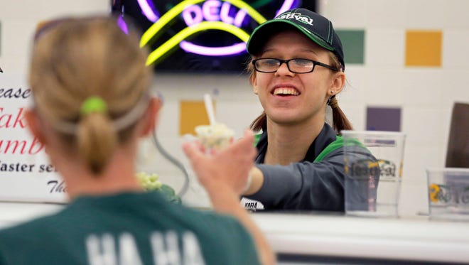 Kaela Lundeen offers a customer a food sample while working in the deli at Festival Foods on Sunday, September 11, 2016 in Appleton, Wisconsin. She is pursuing a paralegal degree at Fox Valley Technical College, but has to take a semester off because her financial aid did not come through.