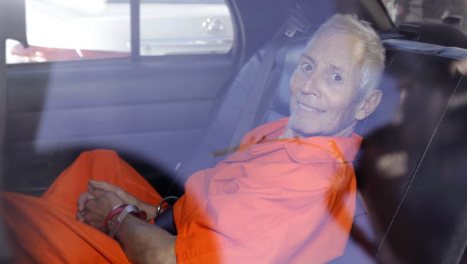 Robert Durst is transported from Orleans Parish Criminal District Court to the Orleans Parish Prison after his arraignment in New Orleans, Tuesday, March 17, 2015.  Durst was rebooked on charges of being a convicted felon in possession of a firearm, and possession of a weapon with a controlled dangerous substance, a small amount of marijuana. (AP Photo/Gerald Herbert)
