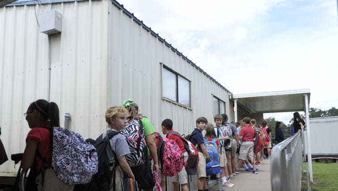 Students wait to enter a temporary classroom building in Lafayette Parish. The district would like to use tax proceeds to eliminate such temporary facilities.
