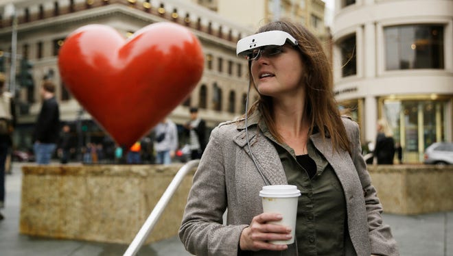 In this photo taken Thursday, Feb. 2, 2017, Yvonne Felix wears eSight electronic glasses and looks around Union Square during a visit to San Francisco. The glasses enable the legally blind to see. Felix was diagnosed with Stargardt's disease after being hit by a car at the age of seven.