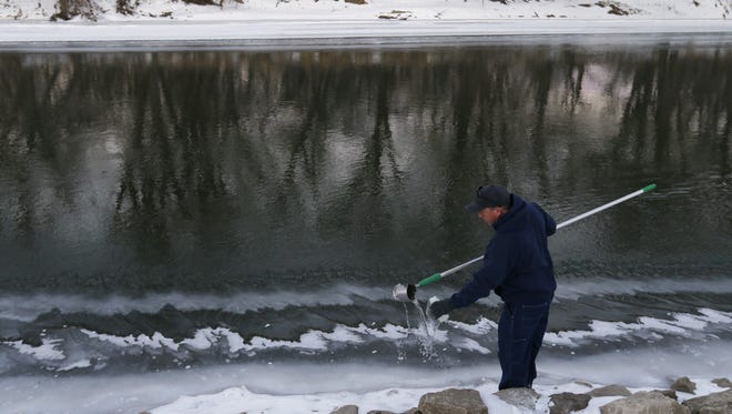Bill Blubaugh, lab technician with Des Moines Water Works, collects water samples Thursday, Jan. 15, 2015, at multiple points along the Raccoon River in Des Moines.