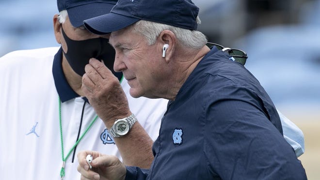 North Carolina coach Mack Brown, front, confers with staff member Ken Browning before the Tar Heels' victory against Syracuse to open the season.