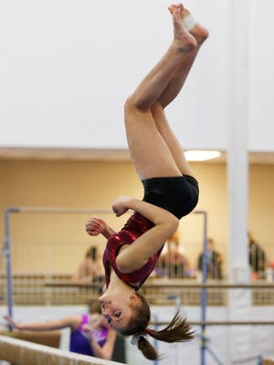 McCutcheon gymnast Emma Taylor practices her dismount from the balance beam Wednesday, January 18, 2017, at Elite Gymnastics, 3822 Fortune Drive in Lafayette. Taylor is a sophomore.