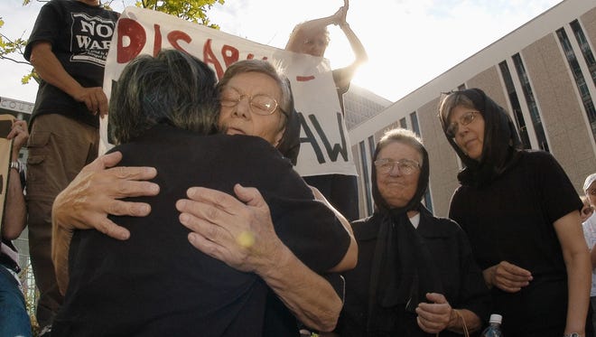 FILE - In this July 25, 2003 file photo, Sister Ardeth Platte, second from left, hugs an unidentified supporter, left, as sisters Jackie Hudson, third from left, and Carol Gilbert, right, look on as the three Dominican nuns head into federal court in downtown Denver for sentencing. The women were convicted in April of obstructing the national defense and damaging government property for swinging a hammer at the silo and smearing their blood on it in the form of a cross. Fifteen years later, they are returning to deliver the message that nuclear disarmament is at hand. "We're in an extremely dangerous time," Platte said. "A strike could be launched from Colorado within 15 minutes and go 7,000 miles to its target within half an hour. It would be total devastation." On Oct. 9, 2017, they'll present to Peterson Air Force Base personnel a copy of the new United Nations' Treaty on the Prohibition of Nuclear Weapons.  (AP Photo/David Zalubowski, File)