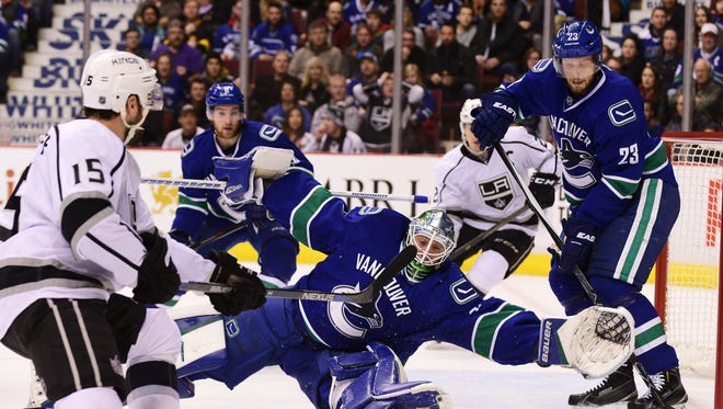 Los Angeles Kings forward Andy Andreoff (15) shoots against Vancouver Canucks goaltender Jacob Markstrom (25) during the first period at Rogers Arena.