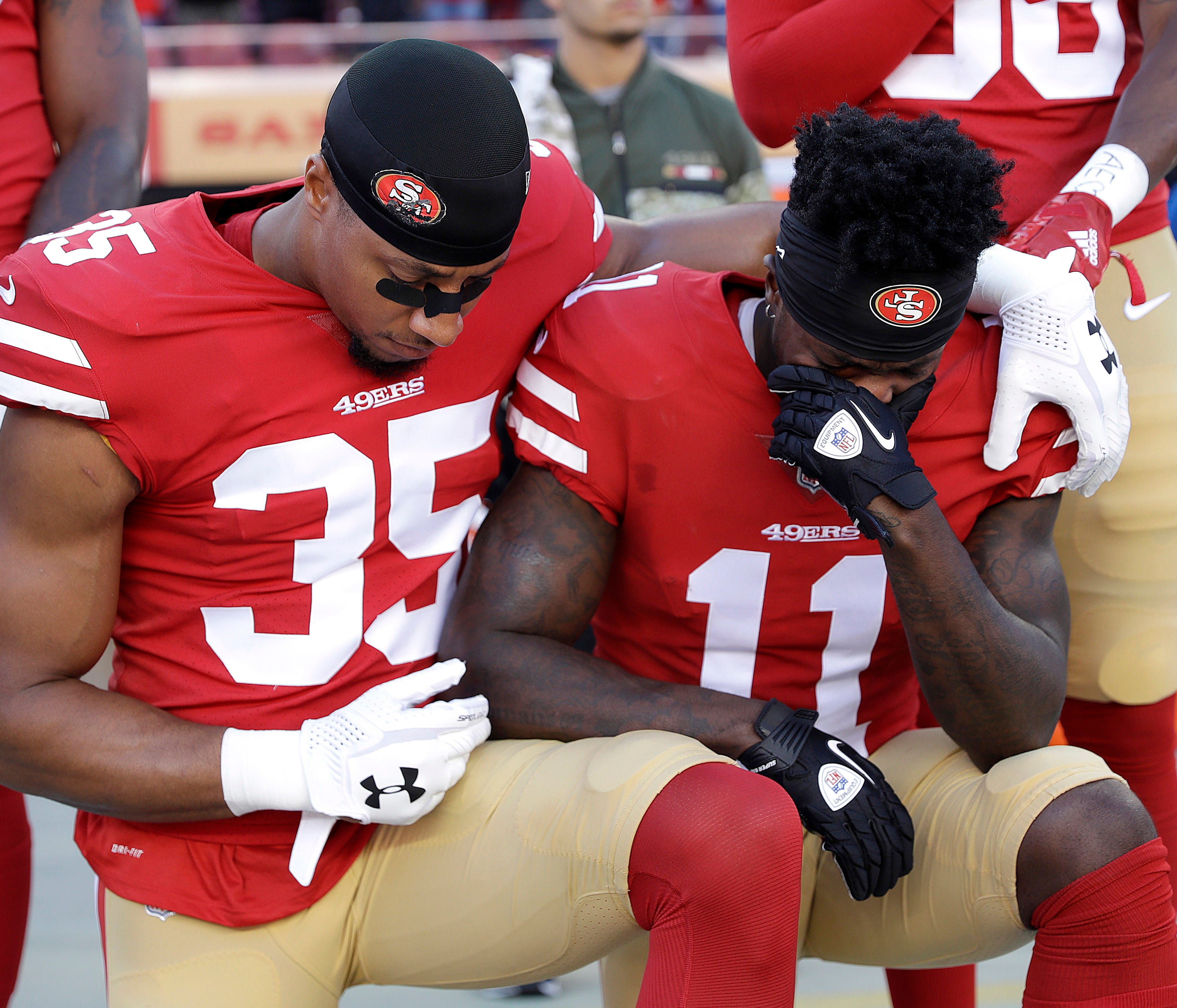 San Francisco 49ers safety Eric Reid (35) and wide receiver Marquise Goodwin (11) kneel during the performance of the national anthem before an NFL football game against the New York Giants in Santa Clara, Calif., Sunday, Nov. 12, 2017. (AP Photo/Mar