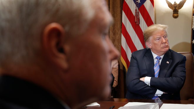 President Donald Trump, right, listens to a member of his cabinet speak during their meeting in Cabinet Room of the White House in Washington, Wednesday, July 18, 2018. Also at the meeting is Vice President Mike Pence, left.