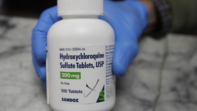 A pharmacist holds a bottle of the drug hydroxychloroquine on Monday, April 6, 2020, in Oakland, Calif. President Donald Trump and his administration kept up their out-sized promotion Monday of an anti-malaria drug not yet officially approved for fighting the new coronavirus, even though scientists say more testing is needed before it's proven safe and effective against COVID-19. Trump trade adviser Peter Navarro championed hydroxychloroquine in television interviews a day after the president publicly put his faith in the medication to lessen the toll of the coronavirus pandemic.