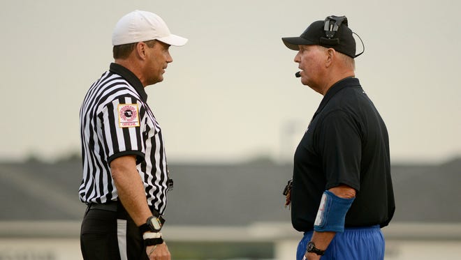 Referee Bob Cannon talks to Stephen Decatur head coach Bob Knox during the first quarter of a 2015 Friday night game at Stephen Decatur high.