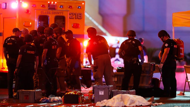A body is covered with a sheet after a mass shooting in which dozens were killed at a music festival on the Las Vegas Strip on Sunday, Oct. 1, 2017. (Steve Marcus/Las Vegas Sun via AP)