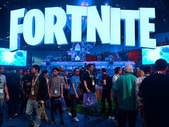 people crowd the display area for the survival game - fortnite wall street journal