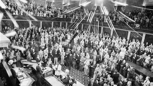 Pres. Jimmy Carter, left at podium, gets a standing ovation from a Joint Session of Congress prior to his report on the SALT II agreement he executed with Soviet Leader Leonid Brezhnev, Monday, June 18, 1979, Washington, D.C. A special filter over the camera lens creates the star pattern from the lights.