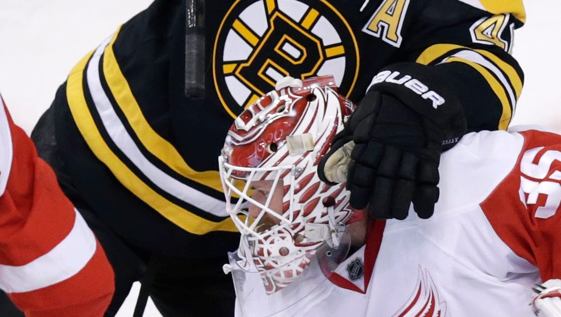 Boston Bruins center David Krejci, left, tangles with Detroit Red Wings goalie Jimmy Howard (35) during the first period of an NHL hockey game in Boston, Monday, Dec. 29, 2014.