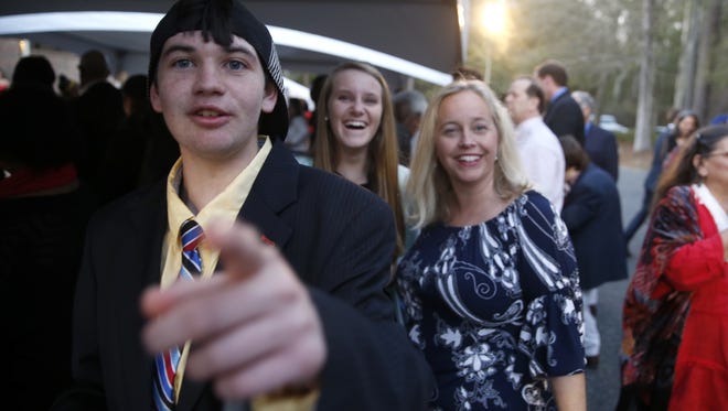 Charlie Harrison, 17, excitedly points out the arrival of a limo, with his sister Cayla, 14, and mother, Hillary Gill in the background before the Night to Shine special needs prom at Genesis Church on Friday, Feb. 12, 2016.