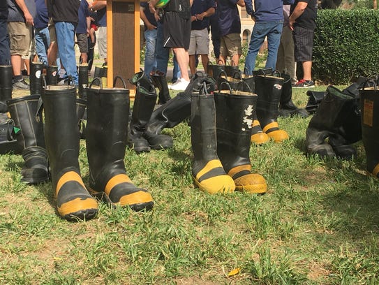 Numerous pairs of boots were placed on the ground at