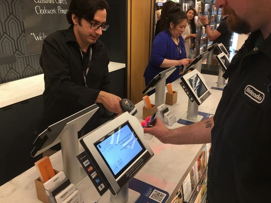 A cashier scans a barcode on a smartphone to complete