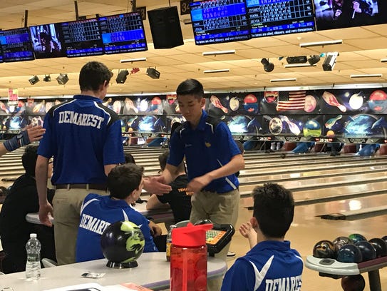 After bowling a strike, Jordan Tse is congratulated